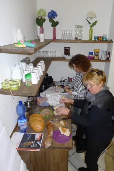 Vorbereitung für die Weinprobe. Petra und Lena schneiden Brot.